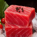 Block of ruby-red tuna on crushed ice garnished with pink peppercorns